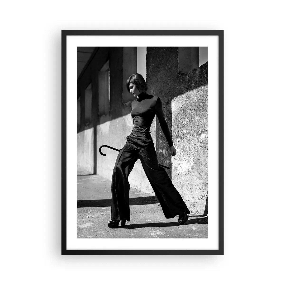 Pôster com moldura preta - Uma mulher com uma roupa elegante e uma bengala contra o pano de fundo de uma arquitetura austera - 50x70cm - Elegância urbana - Decoração de parede moderna para a sala de estar e quarto ARTTOR