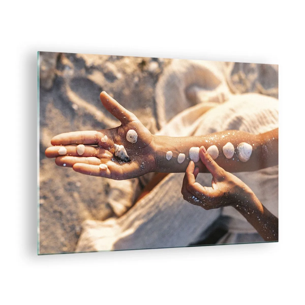 Quadro em vidro - Mãos de criança com conchas sobre fundo de areia e tecido - 70x50cm - Beleza na ponta dos dedos - Decoração de parede moderna para a sala de estar e quarto ARTTOR