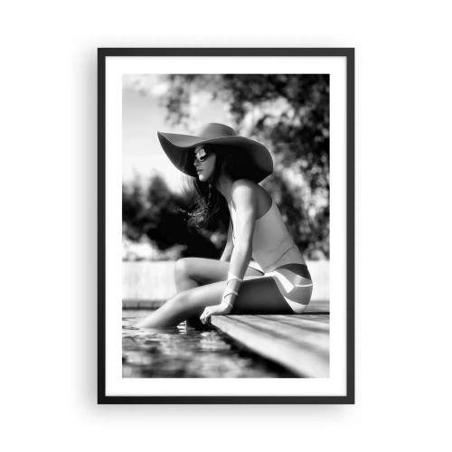 Pôster com moldura preta - Uma fotografia em preto e branco de uma mulher usando um chapéu sentada perto da água. - 50x70cm - Sonho de verão - Decoração de parede moderna para a sala de estar e quarto ARTTOR